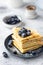 stack crepes with blueberries on gray background