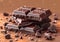 Stack of dark broken chocolate bar pieces with cocoa on brown background.Macro.AI Generative