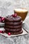 Stack of dark chocolate cookies with cranberry and cup of coffe