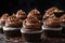 stack of decadent chocolate cupcakes, frosted and decorated with swirls of chocolate