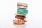 Stack of delicious colorful French macaroons of different flavors on white background.