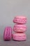 Stack of delicious french pink fruity flavour macarons on grey background