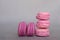 Stack of delicious french raspberry and blueberry flavour macarons on grey background