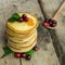 Stack of delicious pancakes with cranberry in rustic style