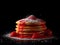 Stack of delicious pancakes with strawberry jam and sugar powder on black background