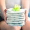 Stack of diapers and soother in the hands of a pregnant woman.