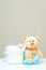Stack of diapers with toy teddy bear with spoon on table