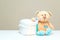 Stack of diapers with toy teddy bear with spoon on table. set for baby shower with copy space