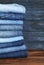Stack of different jeans on table. Space for text