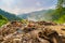 Stack of different types of large garbage dump, plastic bags, and trash burning near paddy rice terraces, agricultural fields of