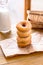 Stack donuts with a bottle of milk on wood background by the window