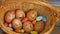 Stack of eggs with hand drawn faces on straw basket with colorful candy, easter preparation, holiday mood concepts