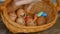 Stack of eggs with hand drawn faces on straw basket with colorful candy, easter preparation, holiday mood concepts