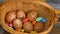 Stack of eggs with hand drawn faces on straw basket with colorful candy, easter preparation, holiday mood concepts