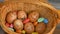 Stack of eggs with hand drawn faces on straw basket with colorful candy, easter preparation, holiday mood concepts