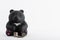 a stack of euro coins next to a piggy bank in the form of a black bear made of clay on a white background