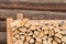 Stack of firewood on log wall background. outdoor storage of woodpile