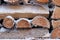 A stack of firewood with snow and hoarfrost in winter