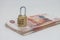 Stack of five thousand ruble banknotes and padlock, financial security concept. Focus stacking