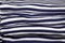 Stack of folded and ironed striped T-shirts close up