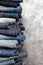 A stack of folded jeans on gray background. Close-up of jeans in different colors. Denim background. Copy space