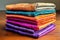 a stack of folded silk sarees in vibrant hues