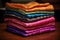 a stack of folded silk sarees in vibrant hues