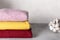 Stack of folded various jumpers on a gray background. Cozy knitted clothes. place for text. close-up