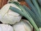 Stack of fresh green leek on a flea market counter. Fresh vegetables background