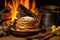 stack of freshly cooked pancakes on a plate beside a roaring campfire