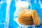 Stack of freshly home baked oatmeal and coconut cookies and glass of milk on blue wood kitchen table. Australian anzac biscuits