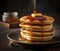 A stack of freshly made pancakes with honey