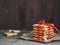 A stack of gift cookies wrapped with a red festive ribbon on a wooden background. Copy space