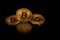 Stack of golden bitcoins isolated on black background with reflection.