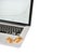 Stack of golden bitcoins placed on silver laptop with blurred financial chart on its screen