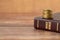 Stack of golden coins on top of holy bible book on a wooden background