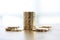 Stack of golden coins on white background with coins lying around on white background.