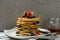 Stack of golden pancakes with fresh fruits