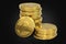 Stack of golden Venezuelan Petro, the oil backed cryptocurrency coin, isolated on black background. 3D rendering