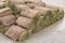 A stack of grassy turf in rolls, grass roll, ready for use in horticulture or landscaping