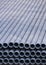 Stack of gray galvanized pipes material inside of construction site