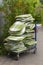 Stack of green and white cushions for garden chairs on a shopping cart