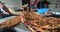 Stack of ground beef pitas put on marble ground with bakers on background working