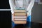 Stack of hardback books in woman hands