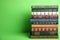 Stack of hardcover books on green background. Space for text