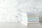 Stack of hardcover books on table against marble background