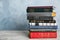 Stack of hardcover books on wooden table against light blue background