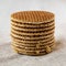 Stack of homemade Dutch stroopwafels with honey-caramel filling on cloth, low angle view. Close-up