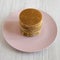 Stack of homemade Dutch stroopwafels with honey-caramel filling on a pink plate, high angle view. Close-up