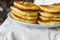 Stack of homemade mascarpone pancakes fritters on plate on white cotton tablecloth. Breakfast setting cozy homely atmosphere